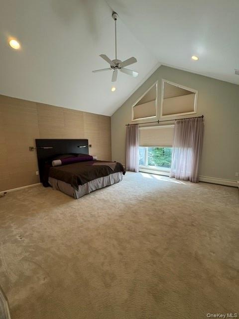 Vaulted ceiling, ceiling fan, recessed lighting, large window with transom windows, and wall-to-wall carpeting