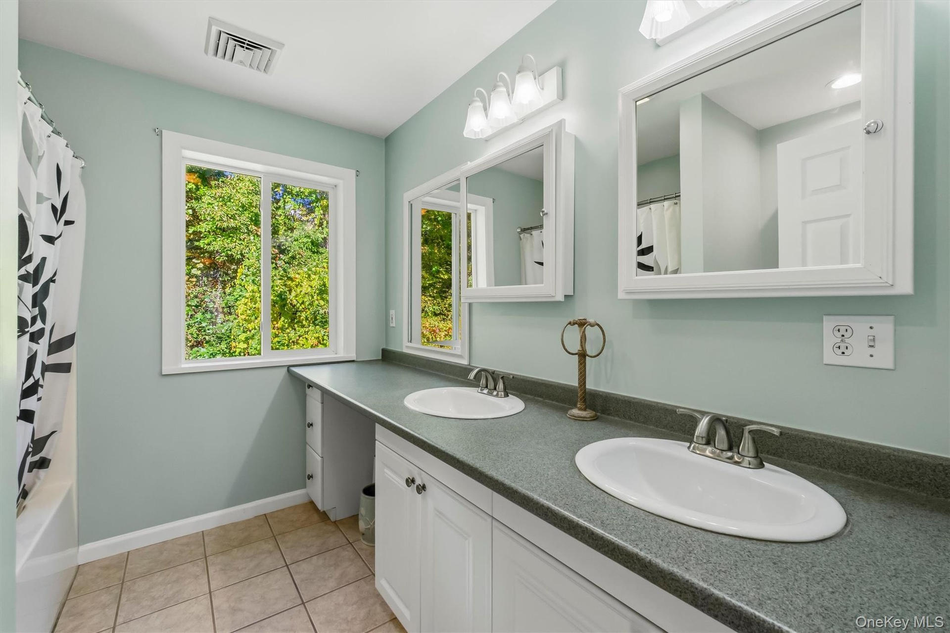 Dual vanity with undermount sinks, white cabinetry, and gray countertops