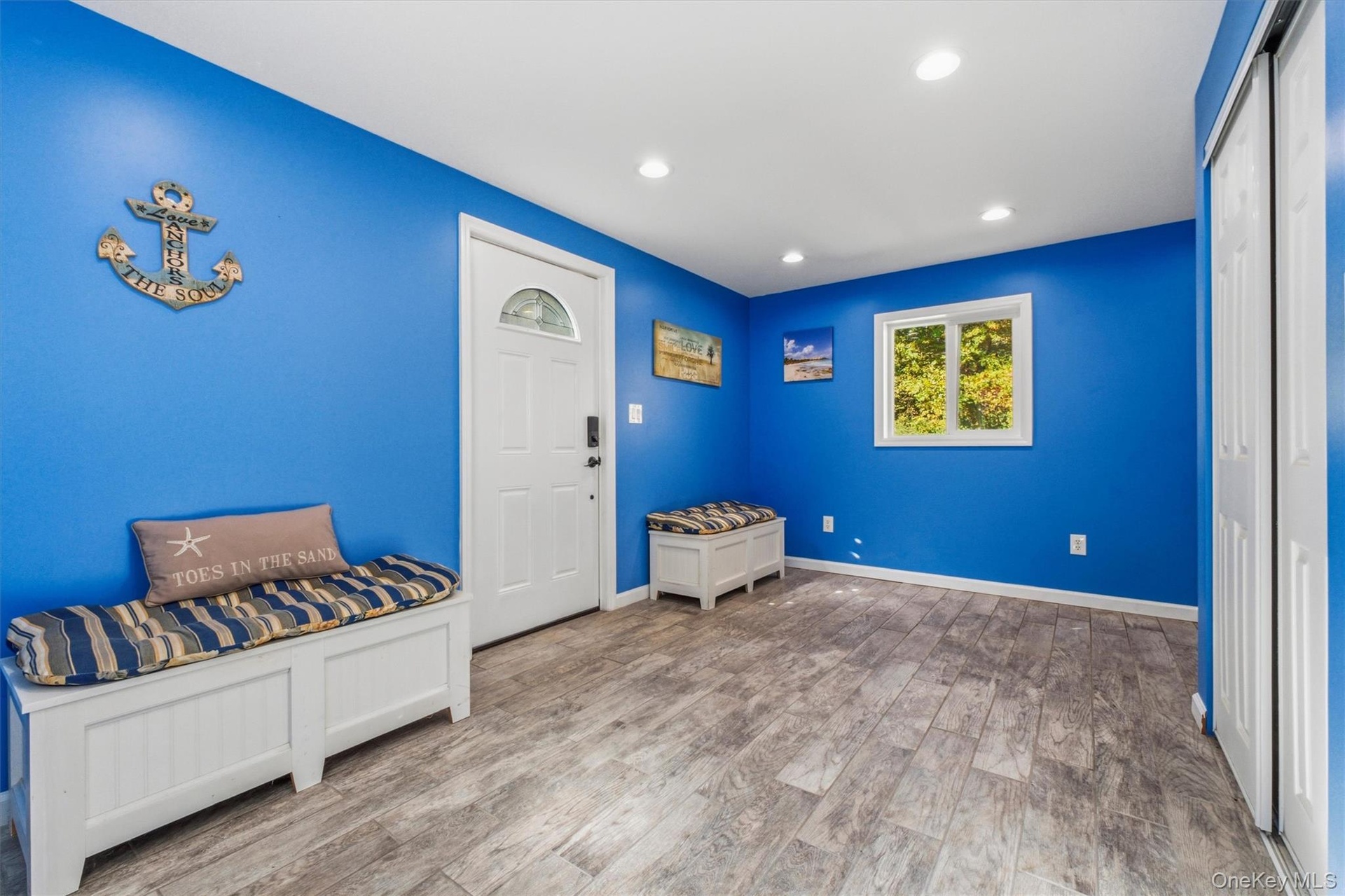 Entry foyer with Wood-finish flooring, recessed lighting, and a window with natural light