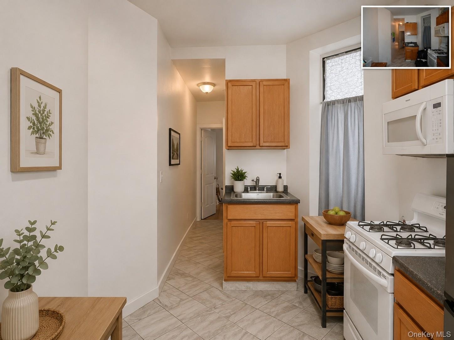 Kitchen featuring wood-finish cabinetry, white appliances, and a stainless steel sink (virtually staged)