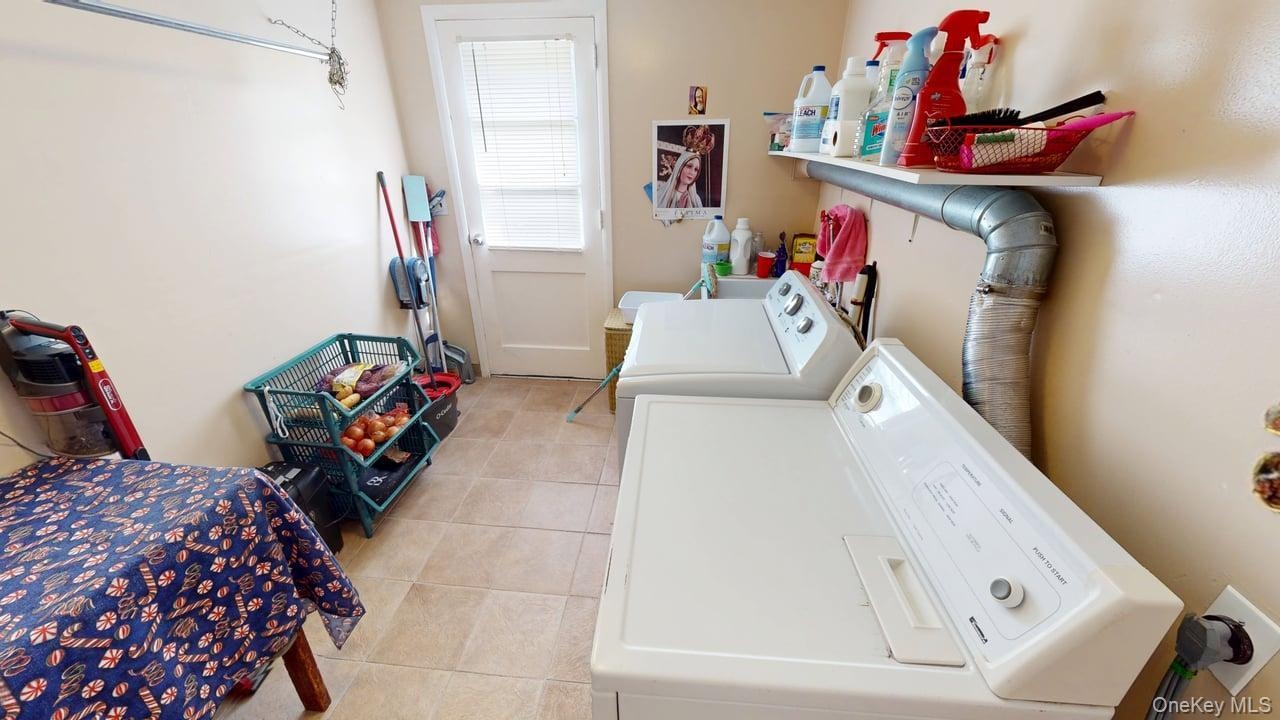 Large laundry Room with shelves and a door to the backyard.
