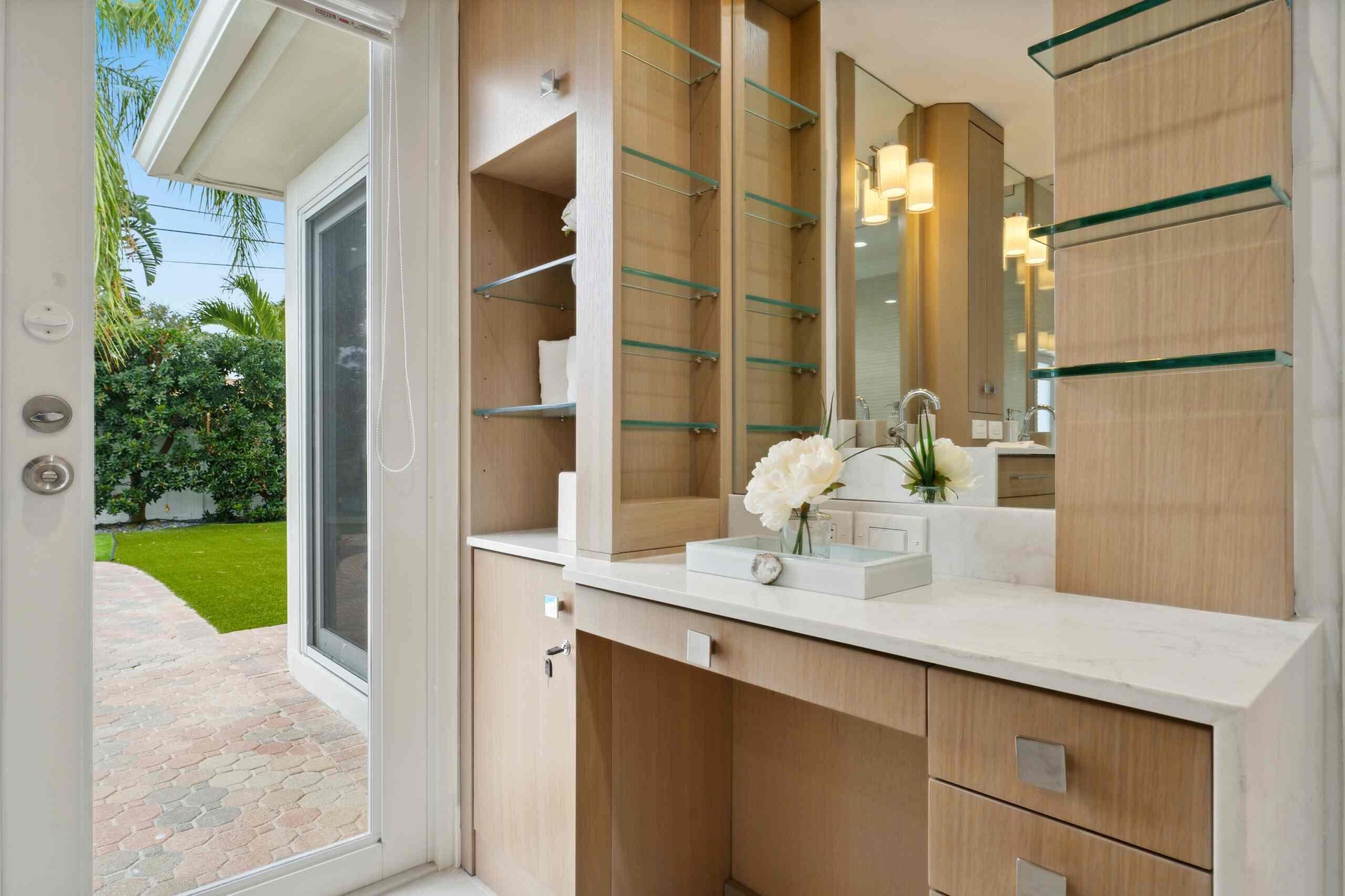 Built-in vanity with wood-finish cabinetry, a light-toned countertop, and integrated sink