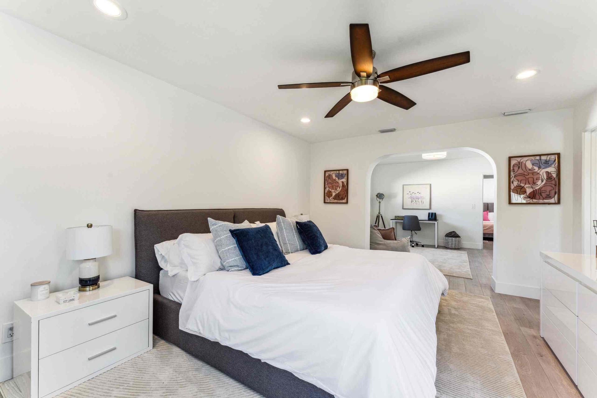 Spacious sleeping area featuring wood-finish flooring, recessed lighting, and a ceiling fan with integrated lighting