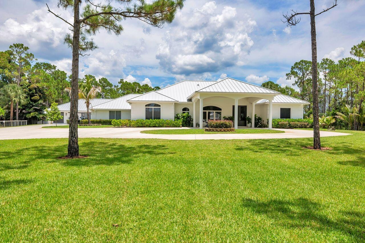 Ranch-style residence featuring a metal roof and a circular drive
