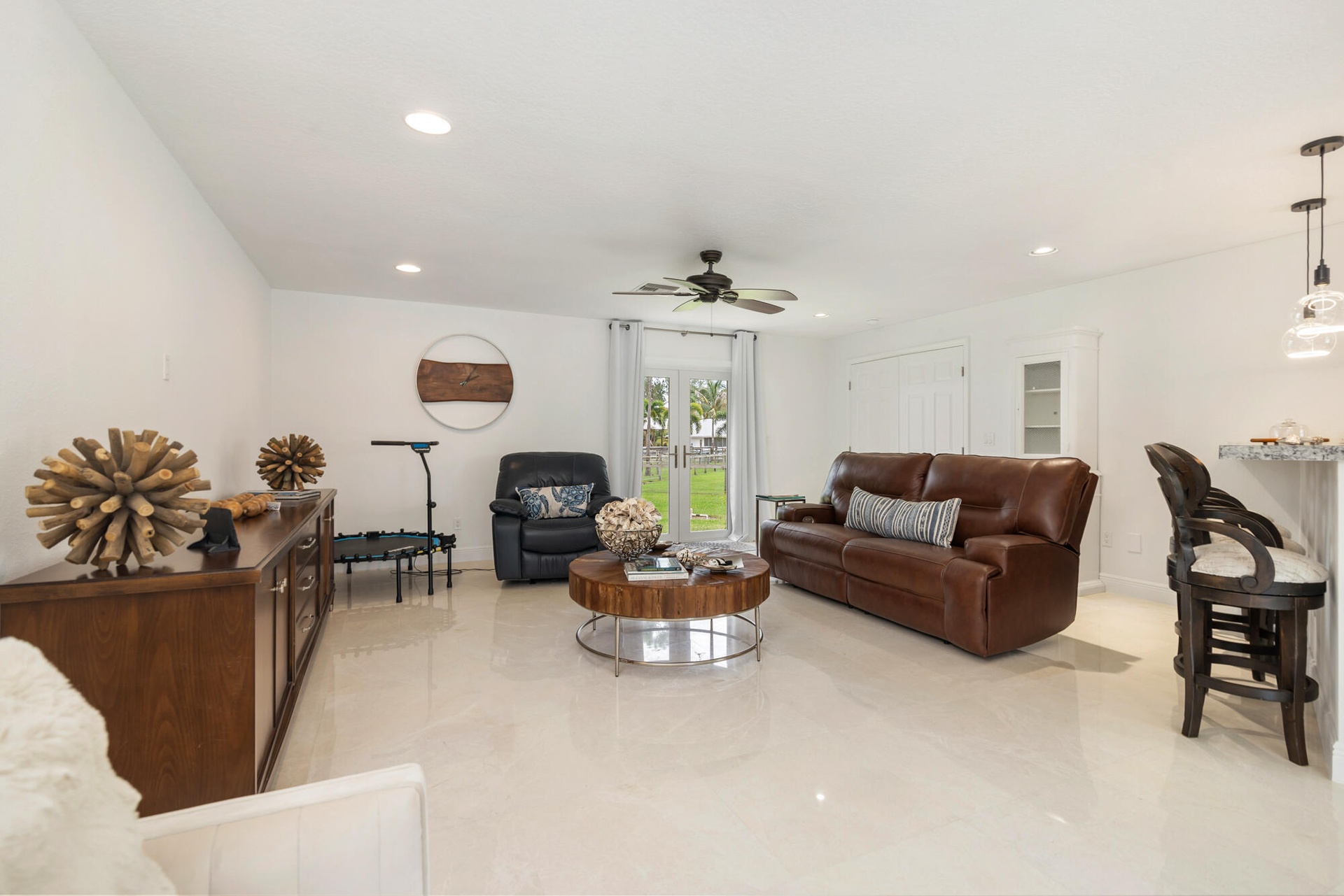 Spacious living area featuring polished marble flooring, recessed lighting, and a ceiling fan