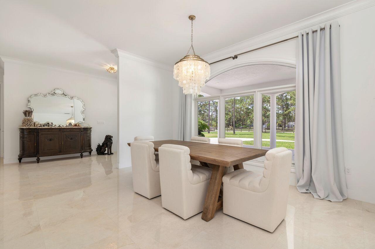 Dining area featuring a large arched window, a decorative chandelier.
