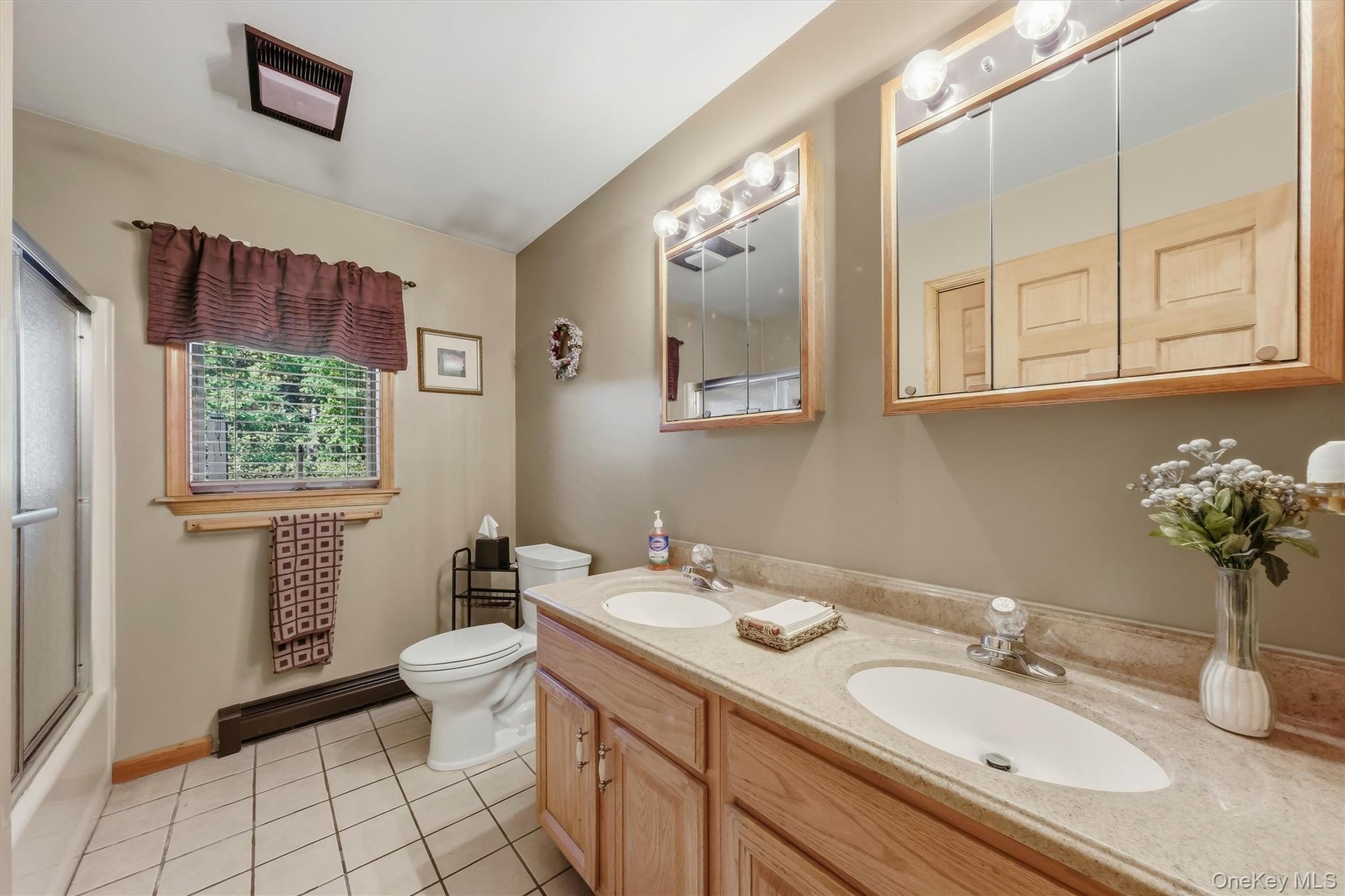 The main bathroom on the first floor is quite spacious and enjoys double sinks, double cabinets, an in-room linen closet and tile floors.