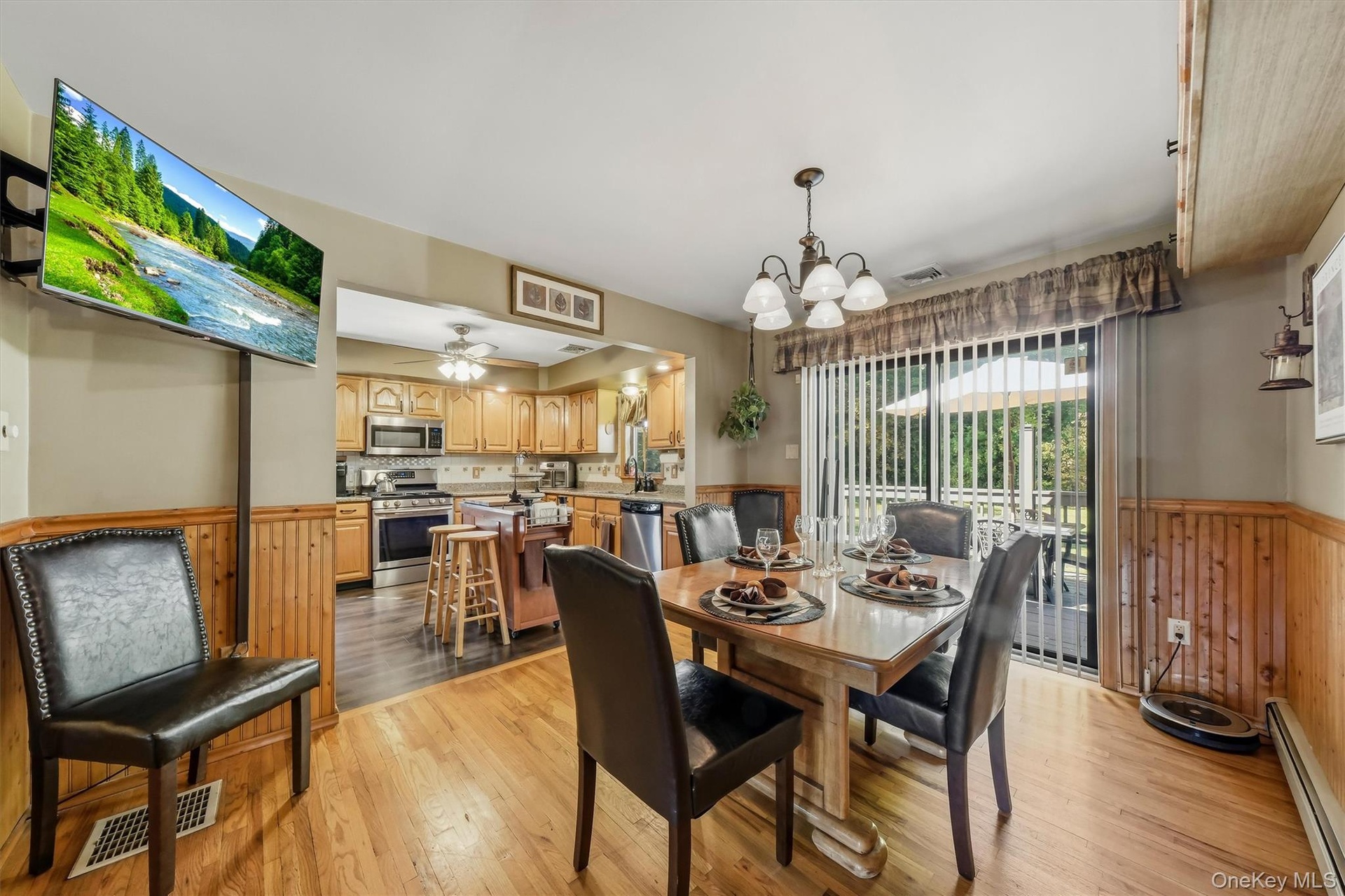 Wainscoting, hardwood floors, and sliders to the deck are a few great features of the dining room.