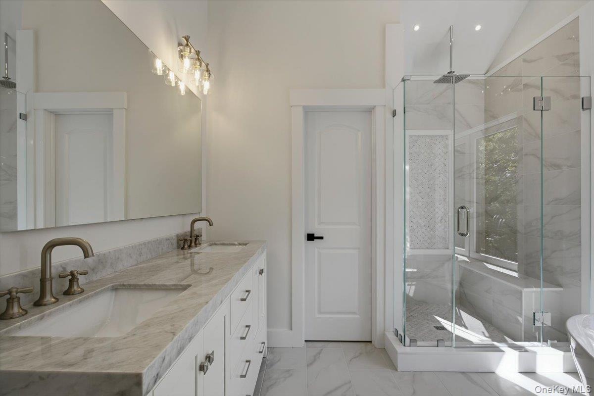 Primary bathroom, walk in shower with sitting bench, rain head and body sprays, separate toilet room