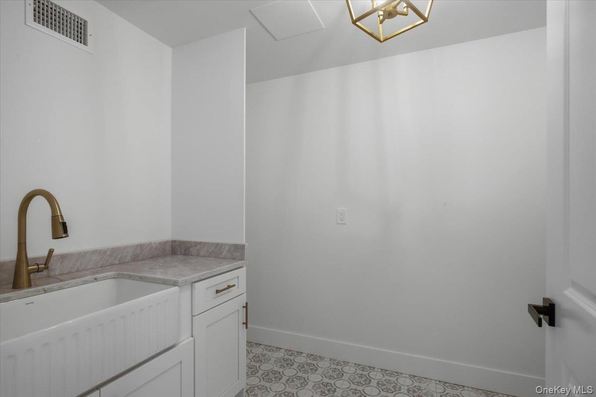 Laundry room with farm sink, cabinets and hook up for washer and dryer