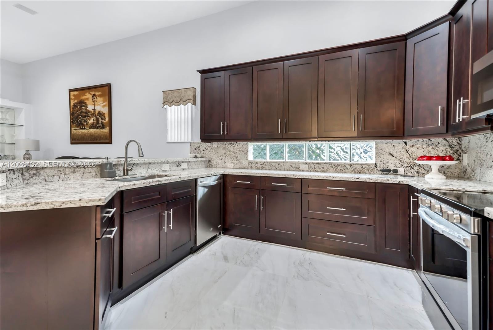 High ceilings, large sliding glass doors, arched entryways, polished stone-finish flooring, and a multi-tiered chandelier