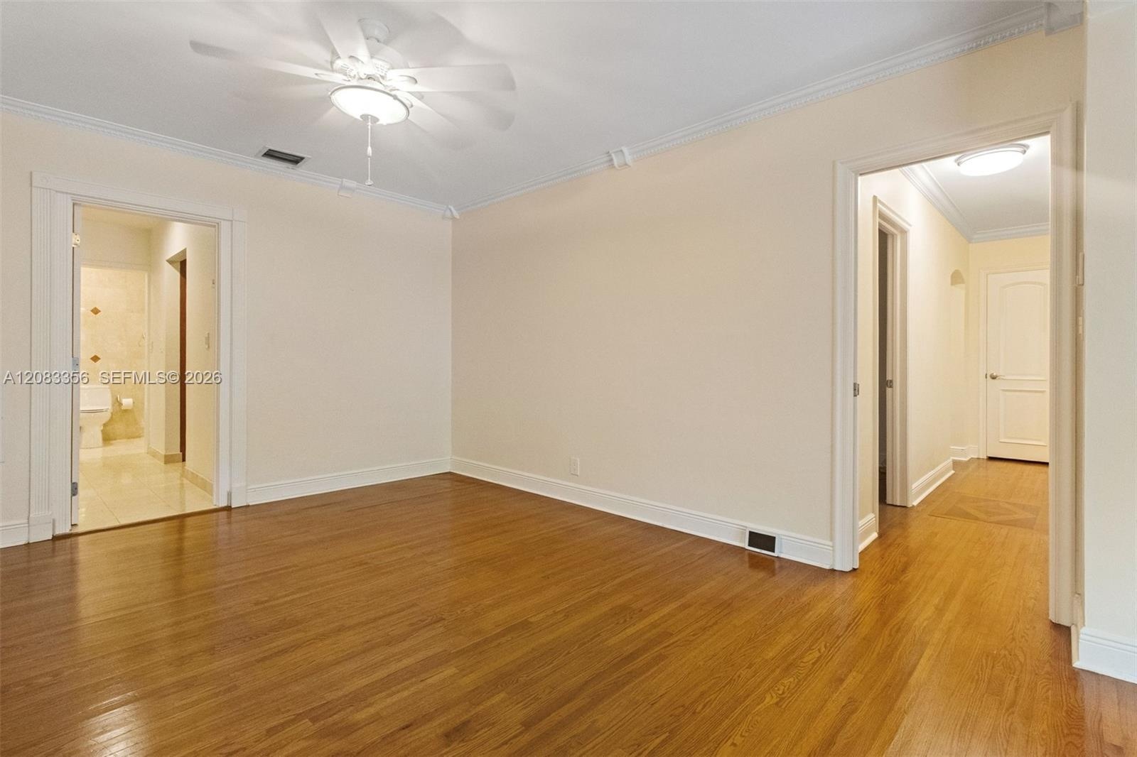 Primary Bedroom with Natural Wood Floors and Ensuite Access to Primary Bathroom