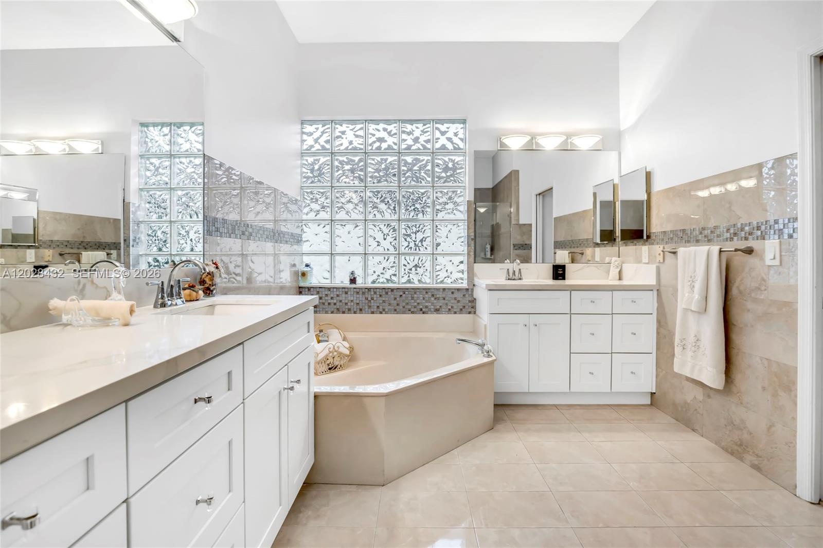 Neutral-toned interior featuring polished tile flooring, a modern three-blade ceiling fan with integrated lighting, and a bi-fold closet door