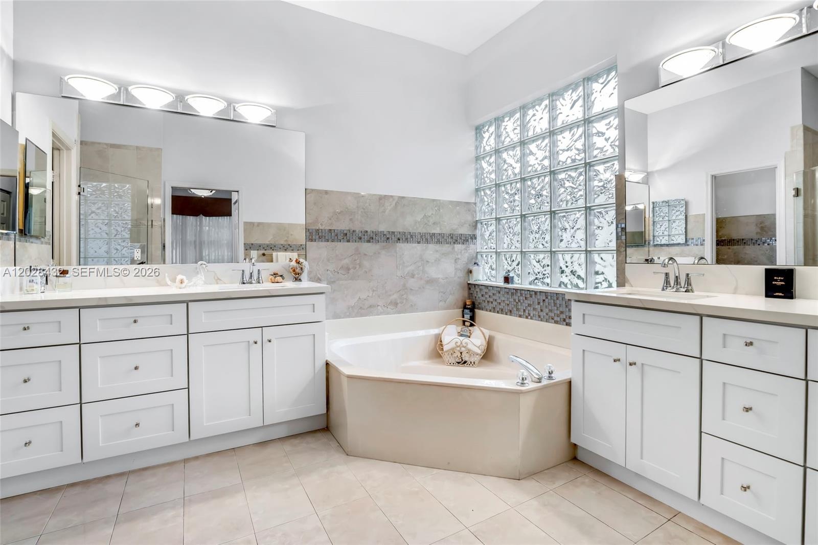 Room featuring neutral wall paint, tile flooring, and a ceiling-mounted fan with integrated light fixture