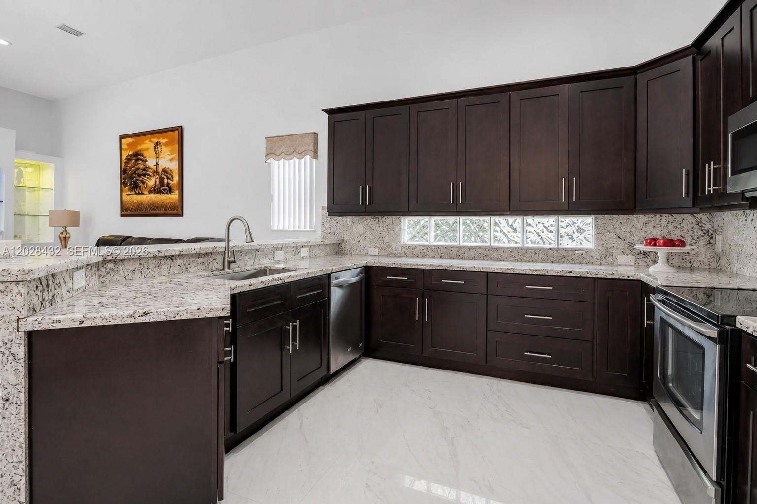 Custom floor-to-ceiling built-in cabinetry with arched shelving, integrated recessed lighting, high ceilings, stone-finish flooring, and a modern ceil