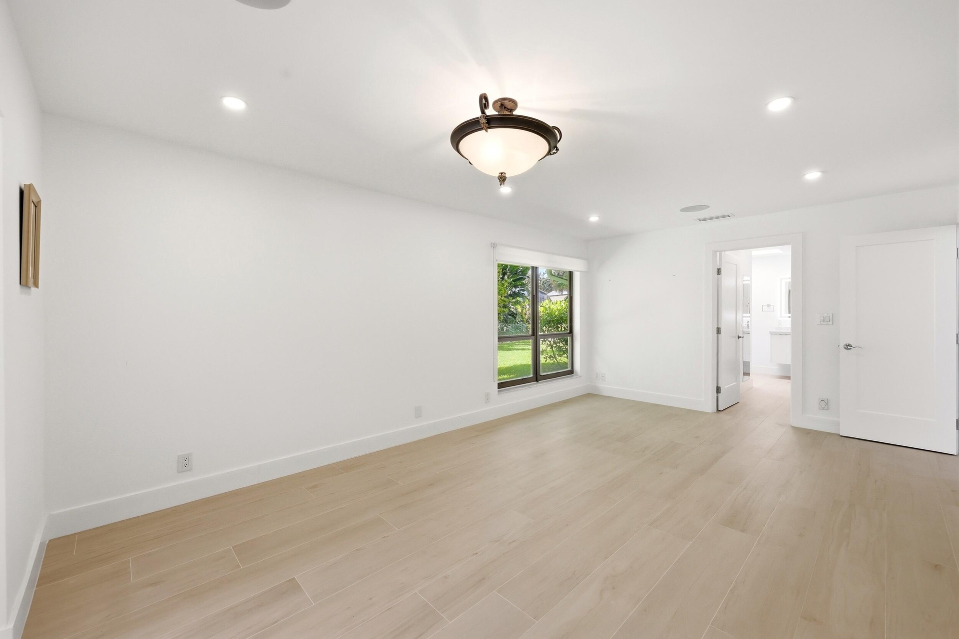 Privately tucked behind contemporary frosted glass barn doors, the primary suite is a tranquil retreat designed for comfort and relaxation. Filled wit