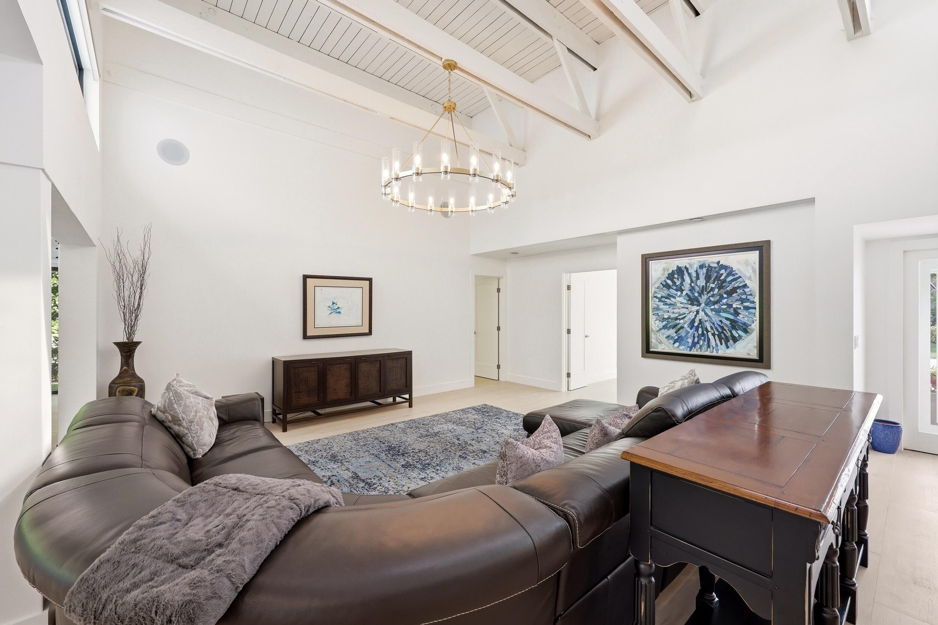 The heart of the home is an impressive open-concept living space defined by soaring vaulted ceilings, exposed beams, skylights, and an abundance of na