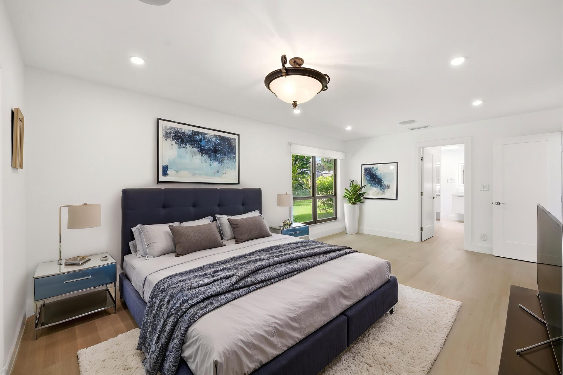 Privately tucked behind contemporary frosted glass barn doors, the primary suite is a tranquil retreat designed for comfort and relaxation. Filled wit