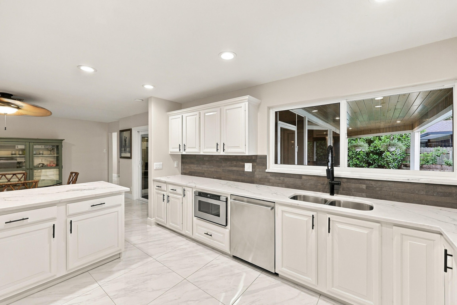 From the kitchen sink, you can admire the resort-style pool, spacious backyard, and 900-square-foot covered and screened-in patio.