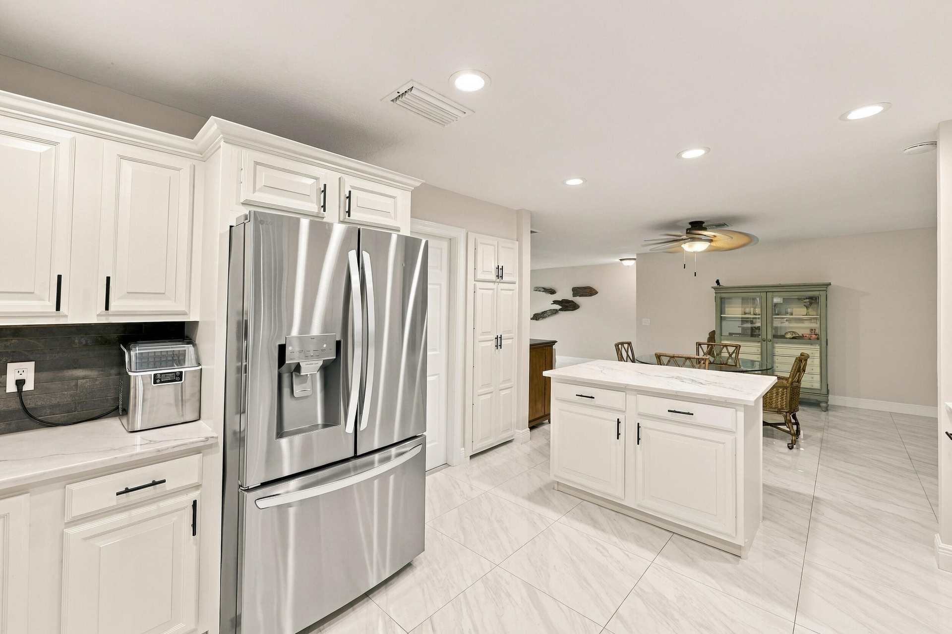 The impeccably upgraded kitchen offers white cabinetry, quartz countertops, stainless steel appliances, and a beautiful charcoal backsplash. There is 
