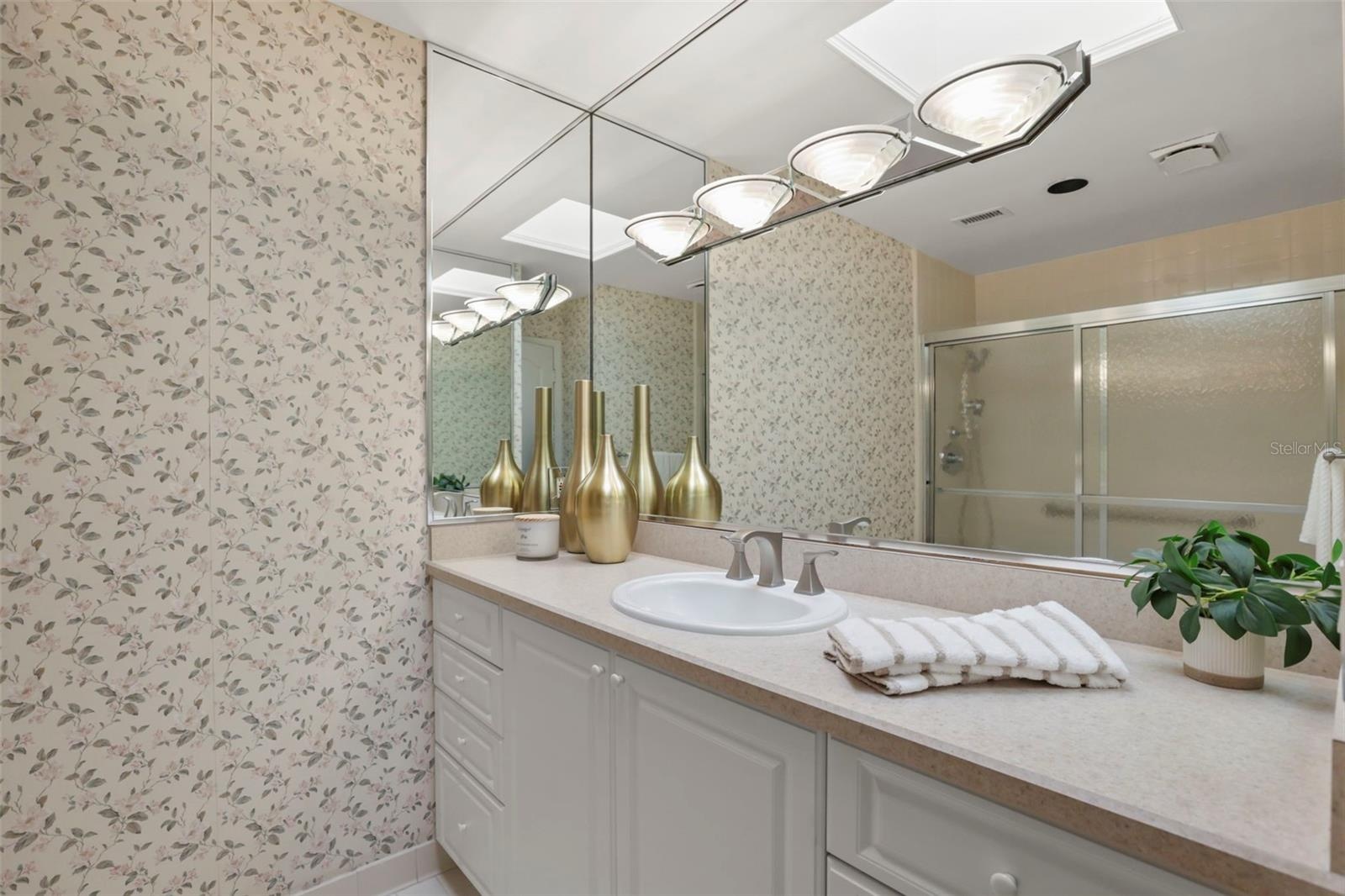 The primary bathroom offers abundant storage in a large vanity area and a full linen closet.