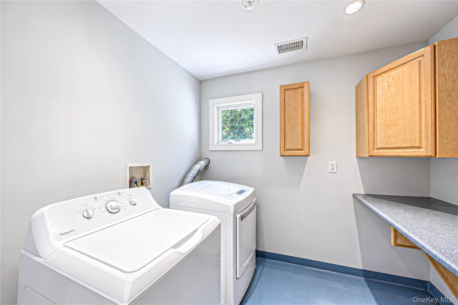 Seconf floor laundry with folding area and cabinetry