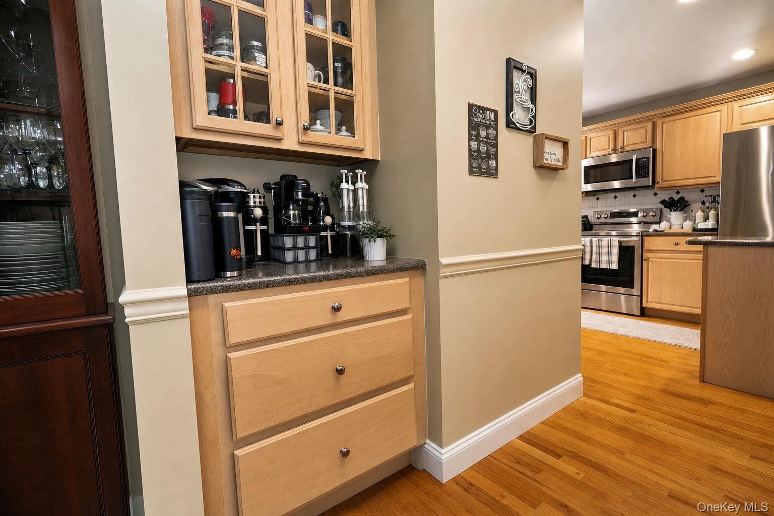 Built-in cabinetry with glass-front uppers, wood-finish flooring, and recessed lighting "coffee nook"