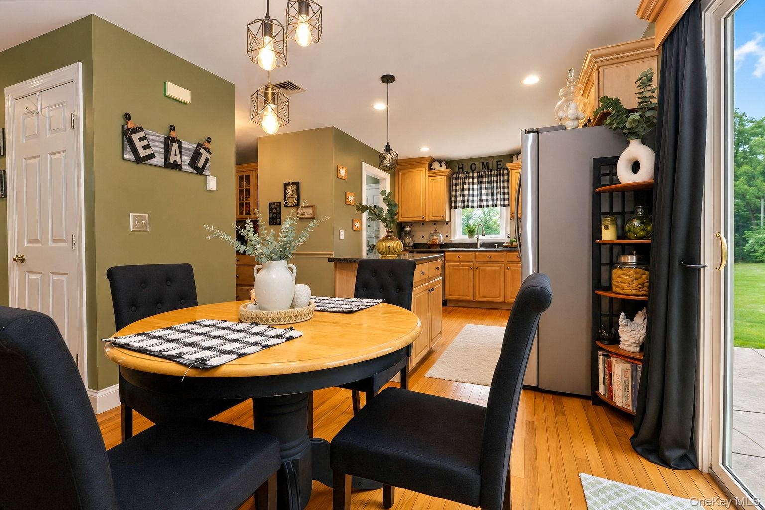 Hardwood flooring, recessed lighting, pendant light fixtures and sliding glass door to rear 2 tiered paver patio