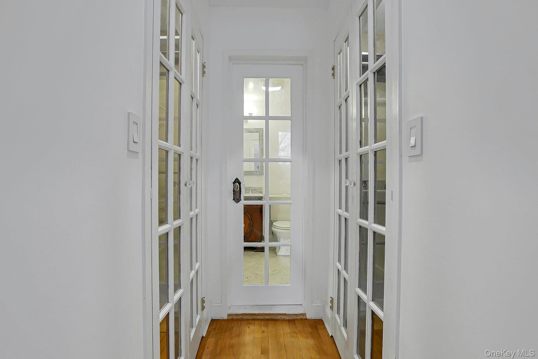 View into primary bathroom and two custom closets.