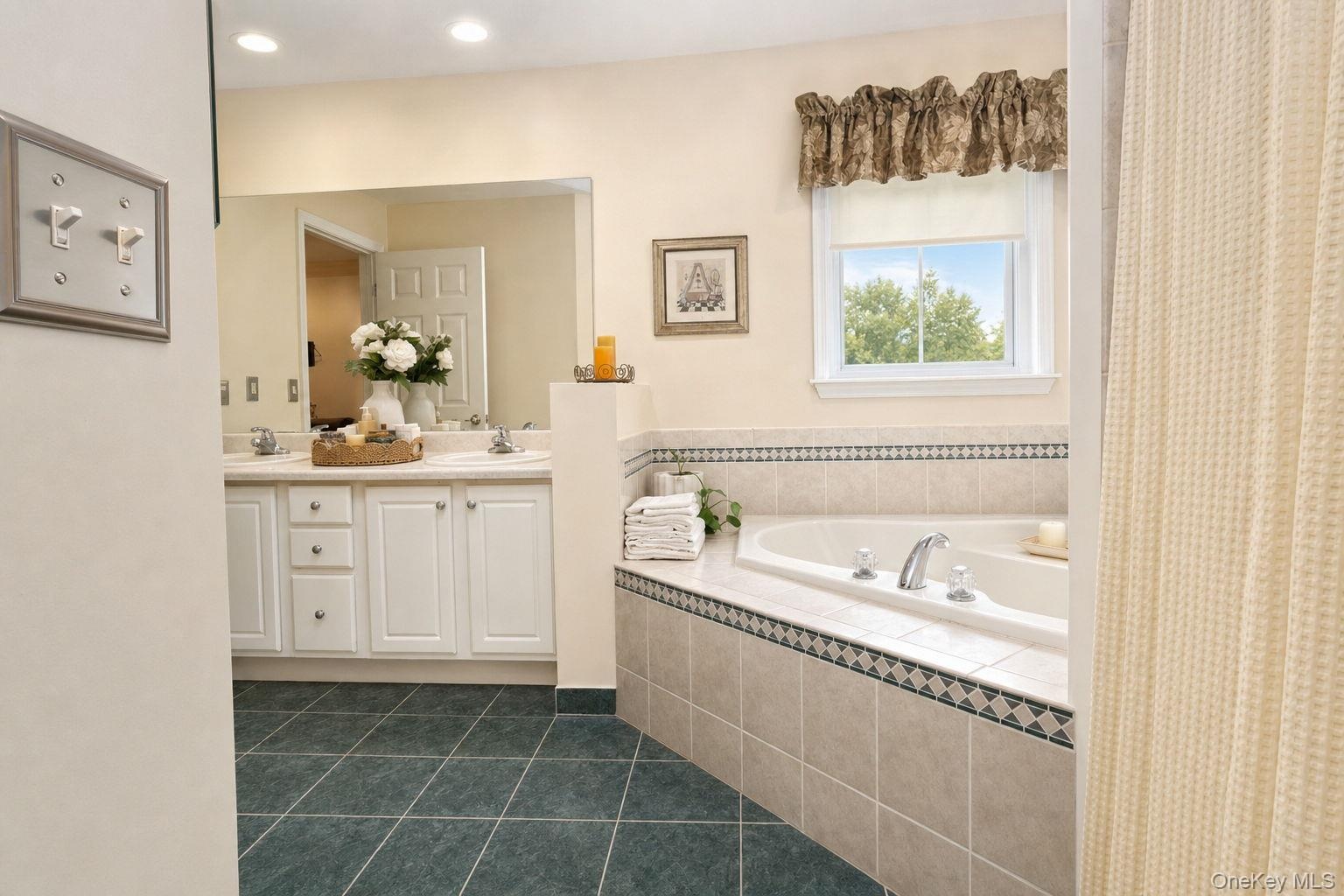 Dual vanity with under-sink storage, built-in soaking tub, window, recessed lighting, tile flooring