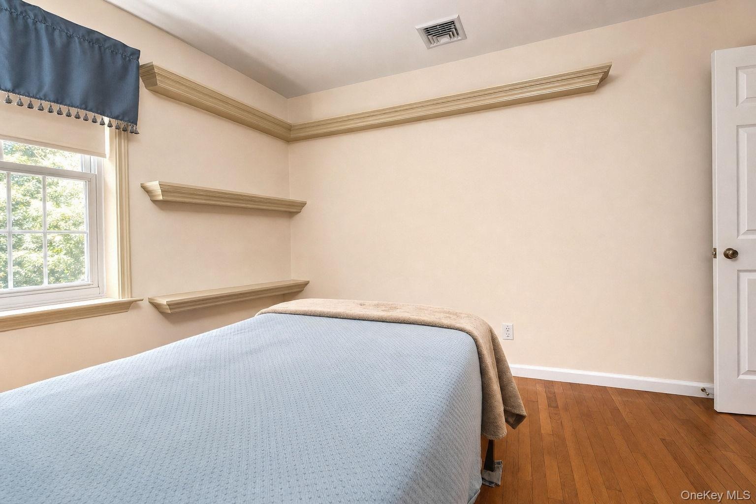 Hardwood flooring, , built-in shelving, paneled door, and a double-hung window