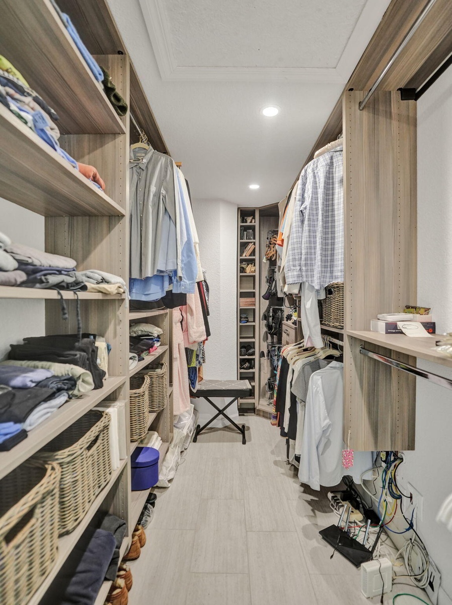 Custom closet organization system with wood-finish shelving and integrated hanging rods