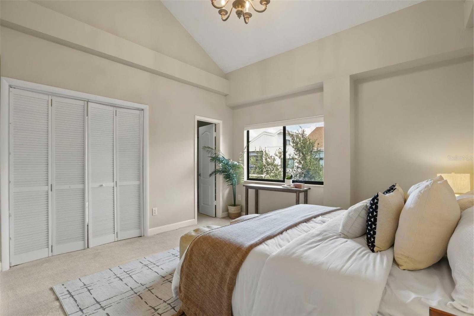The primary suite with a large window overlooking the Park West garden and ornamental pond.
