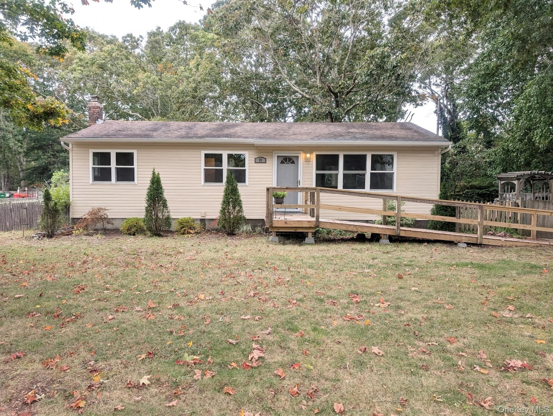 Light-colored siding, multiple windows, and a front entry ramp.