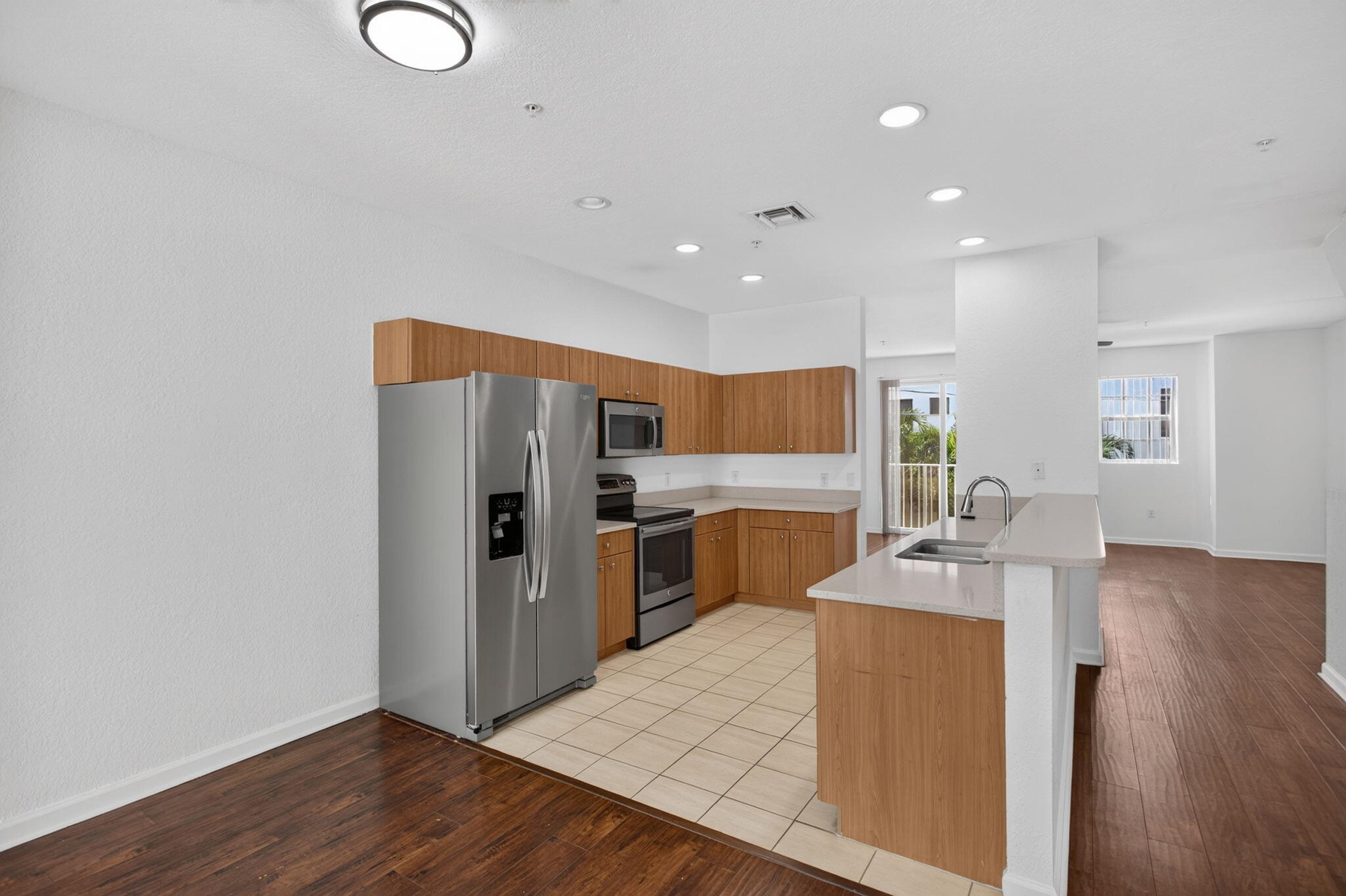 Kitchen featuring wood-finish cabinetry, stainless steel appliances, and light-toned countertops
