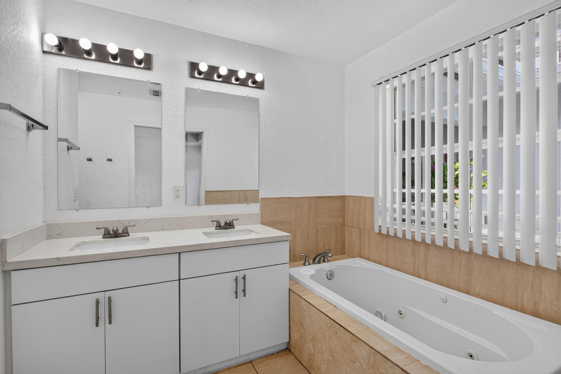 Dual vanity with undermount sinks, white cabinetry, and a light-toned countertop