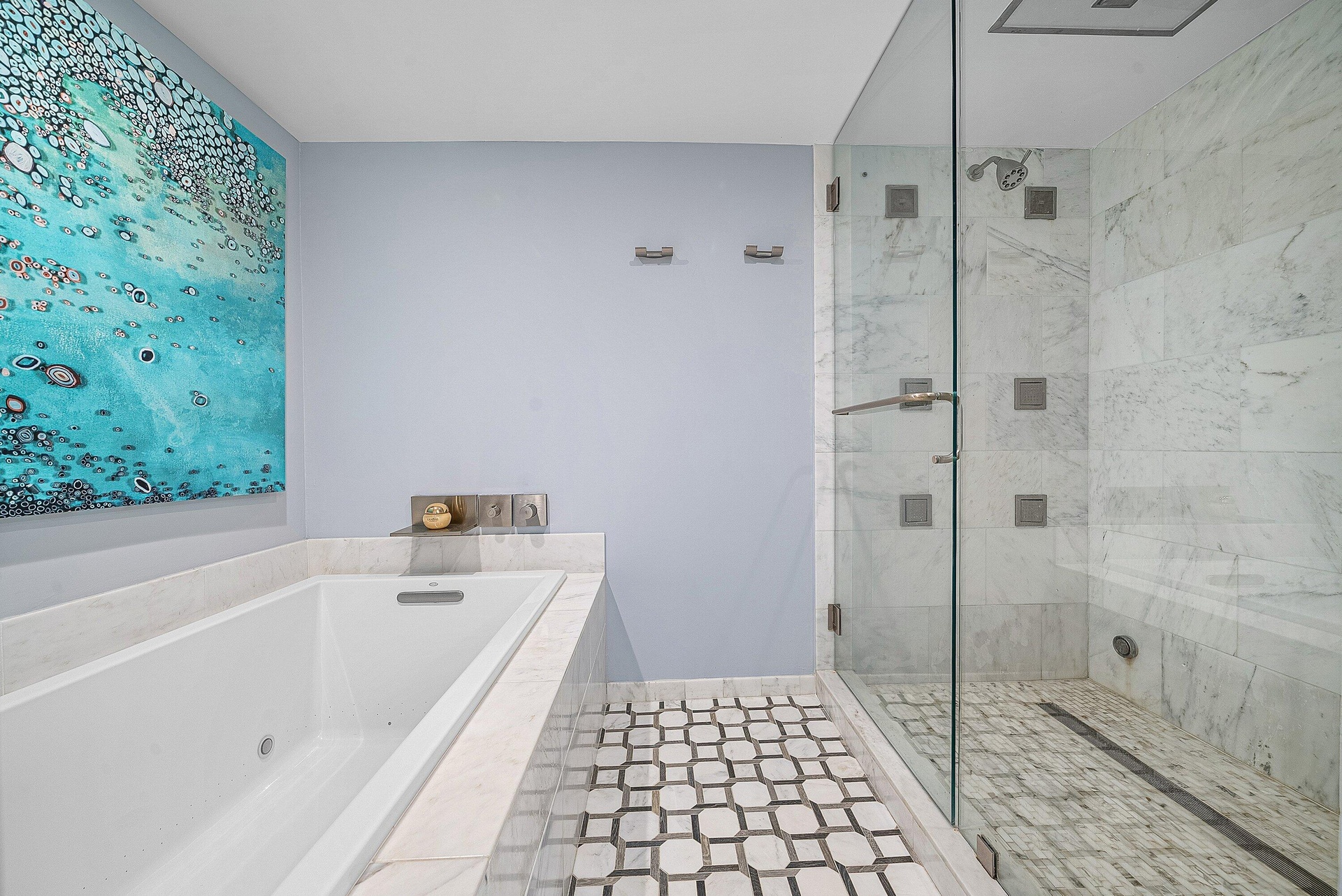 Soaking tub with integrated jets, glass-enclosed shower with multiple body sprays, large format tile shower surround, patterned tile flooring, and int