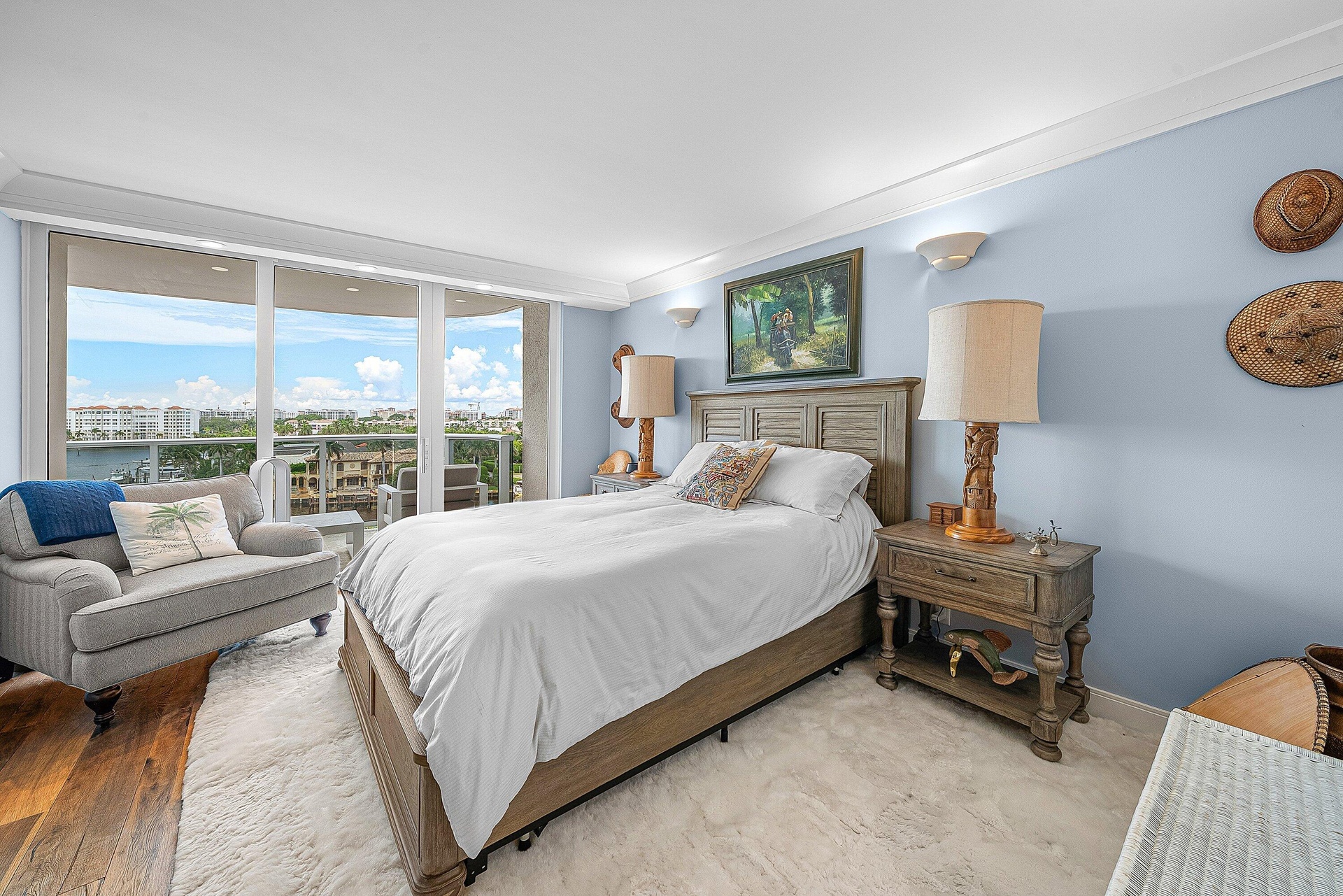 Floor-to-ceiling sliding glass doors, hardwood flooring, crown molding, and wall sconces