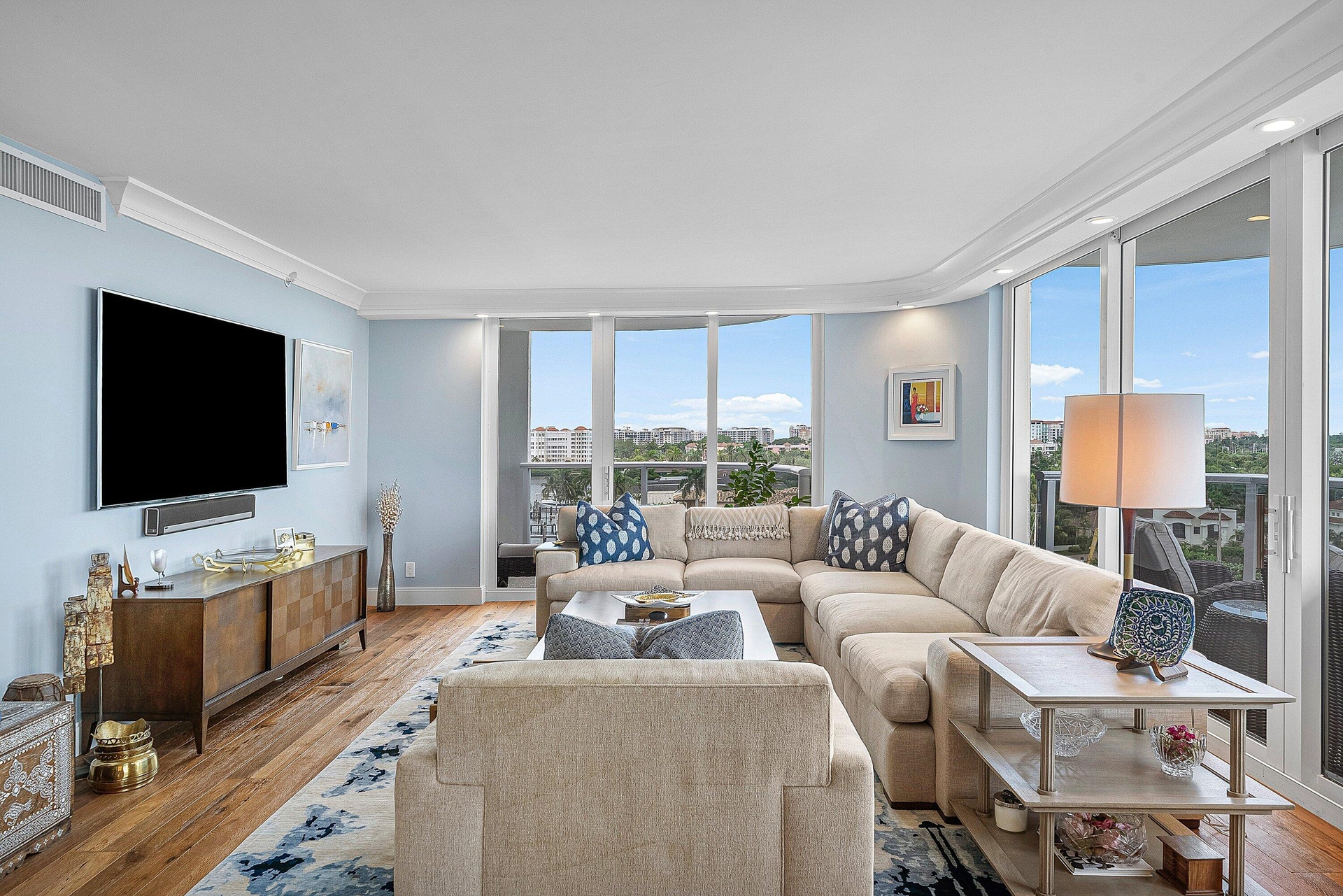 Wood-finish flooring, crown molding, floor-to-ceiling windows, and a built-in wall-mounted television