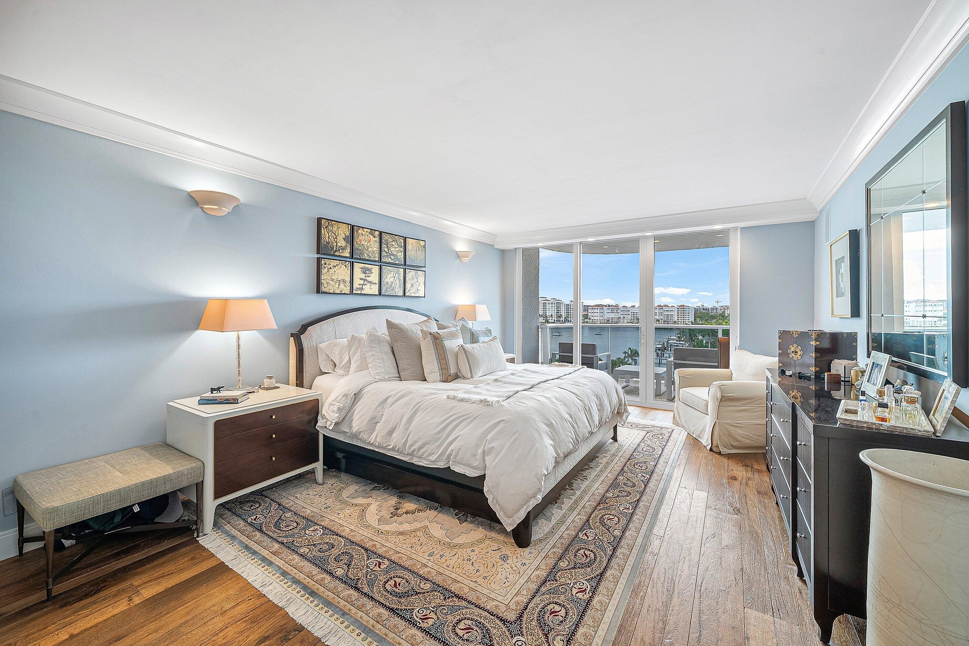 Wood-finish flooring, crown molding, and a sliding glass door leading to a balcony