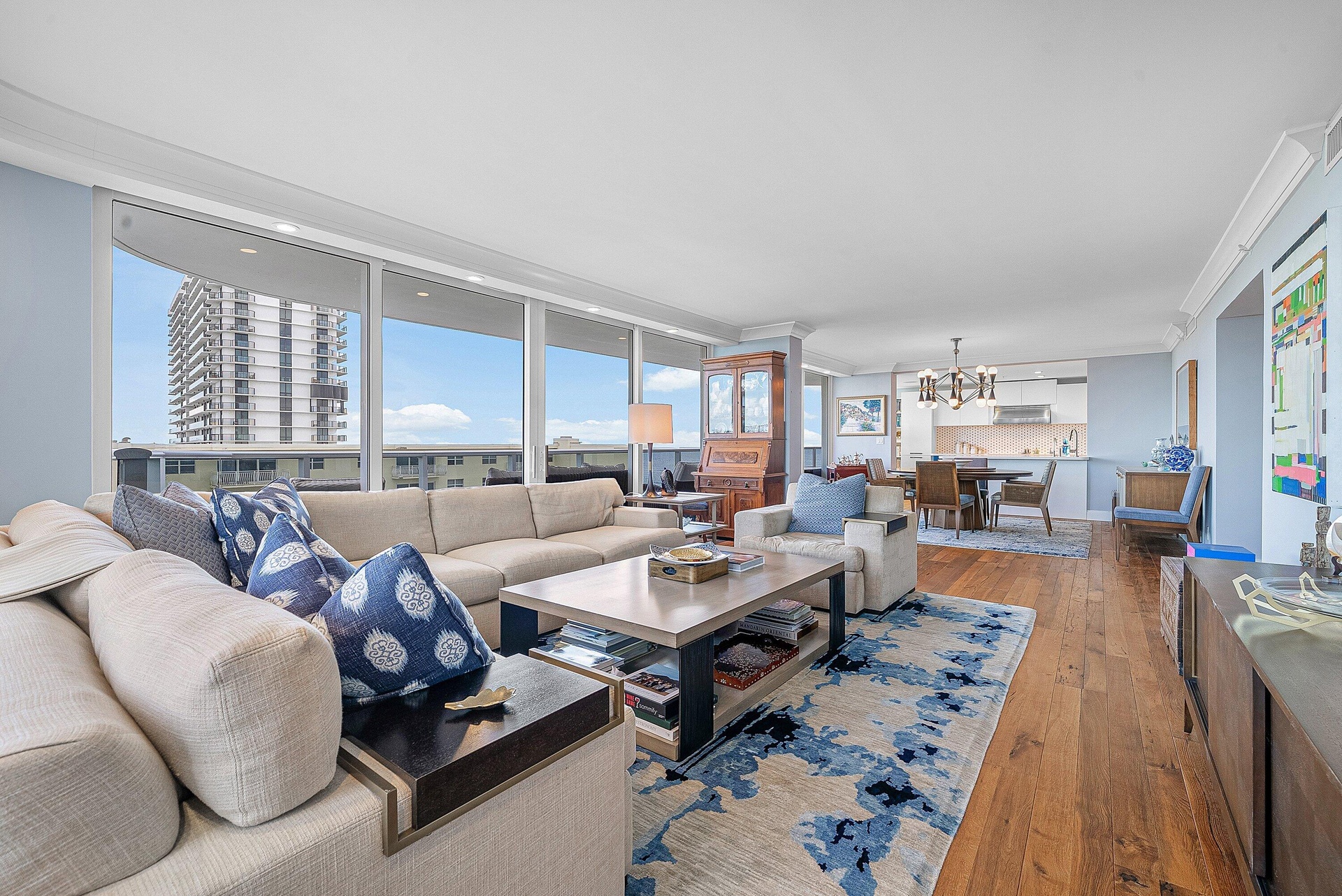 Open-concept living area featuring wood-finish flooring, a full wall of windows, and recessed lighting