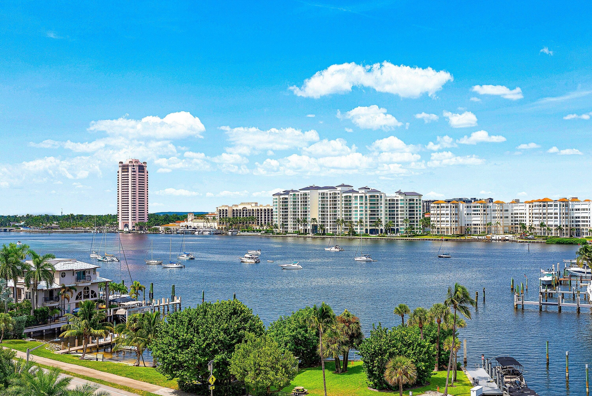 Waterfront scenery featuring a river, multiple buildings, and boats