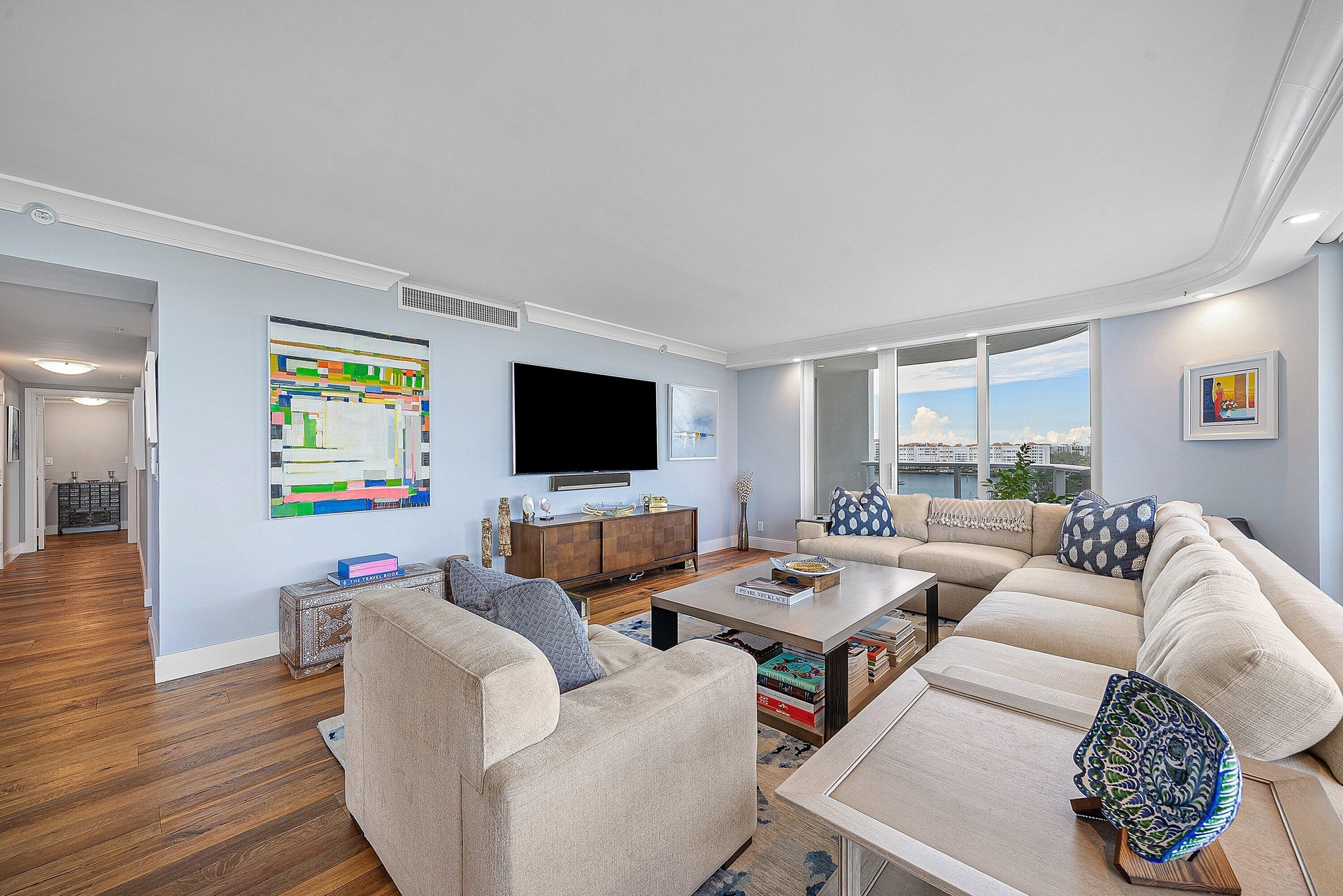 Wood-finish flooring throughout, light blue walls, and white crown molding