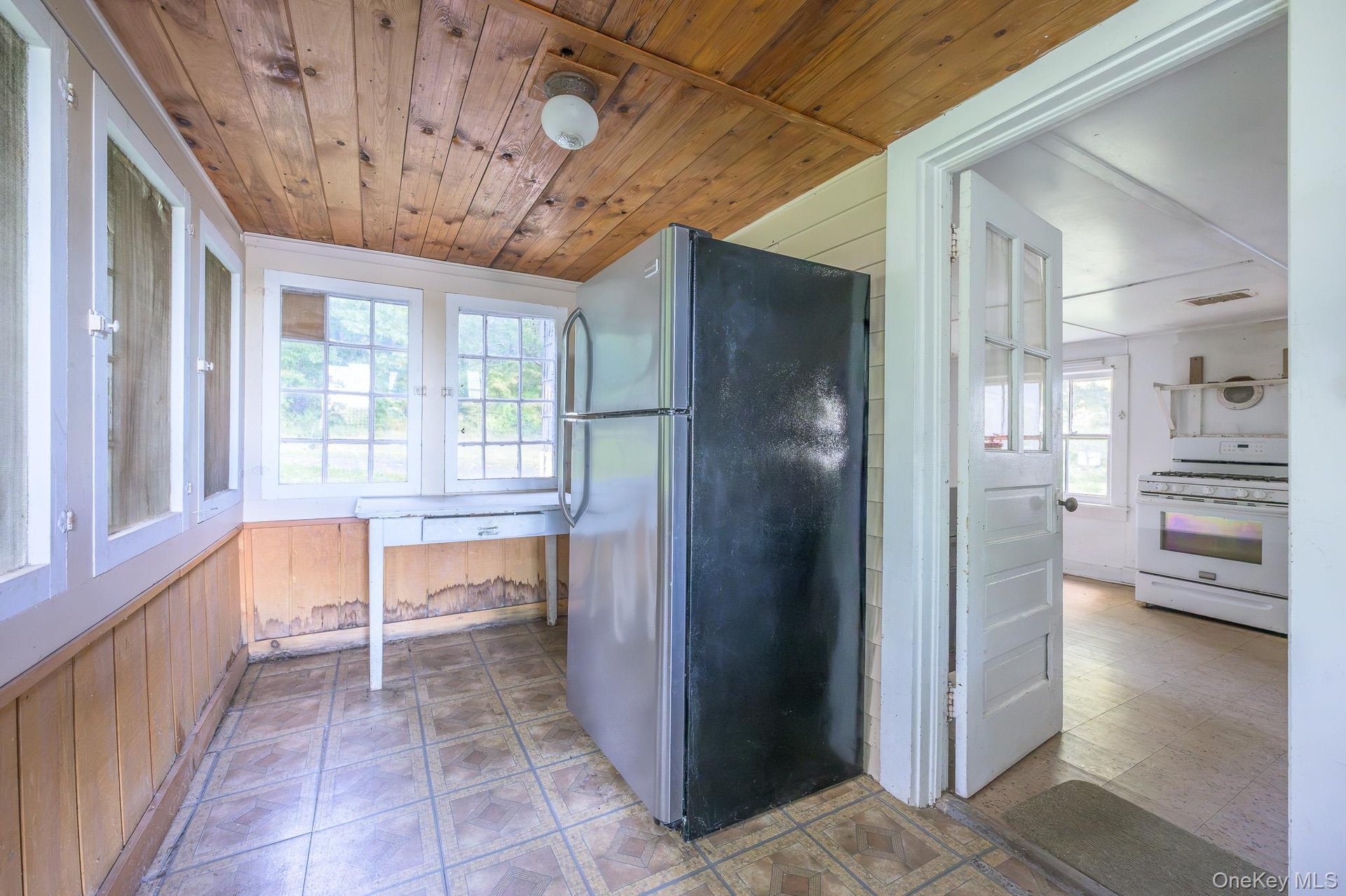 Wood-finish plank ceiling and walls, multiple pane windows, and a tiled floor