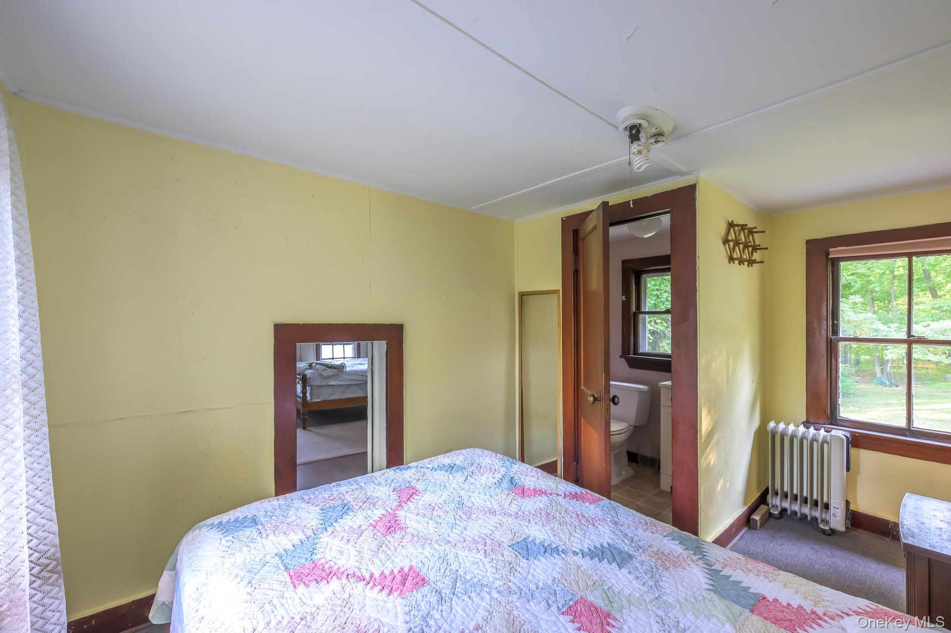Room featuring a window with exterior views, a panel radiator, and a wood-frame doorway