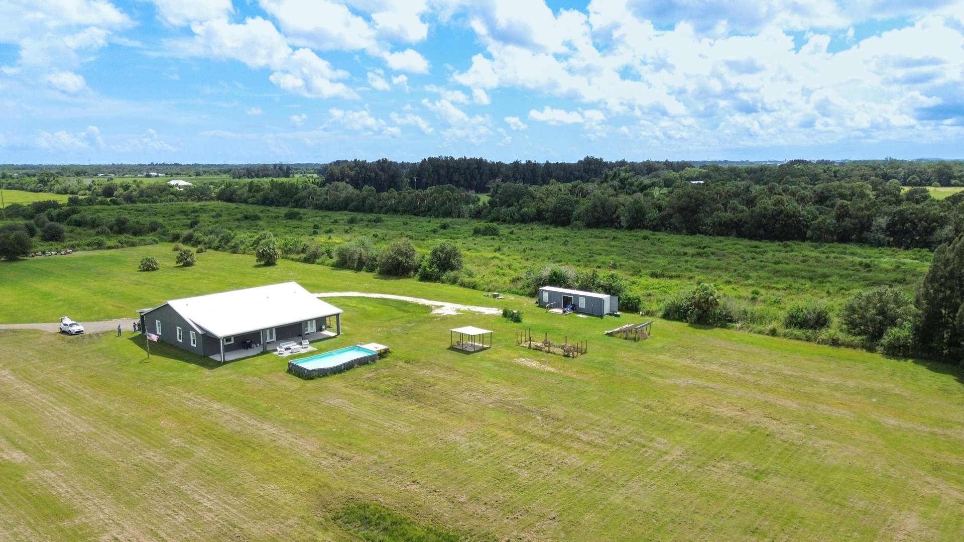 Aerial view of the home, pool and guest unit surrounded by open land
