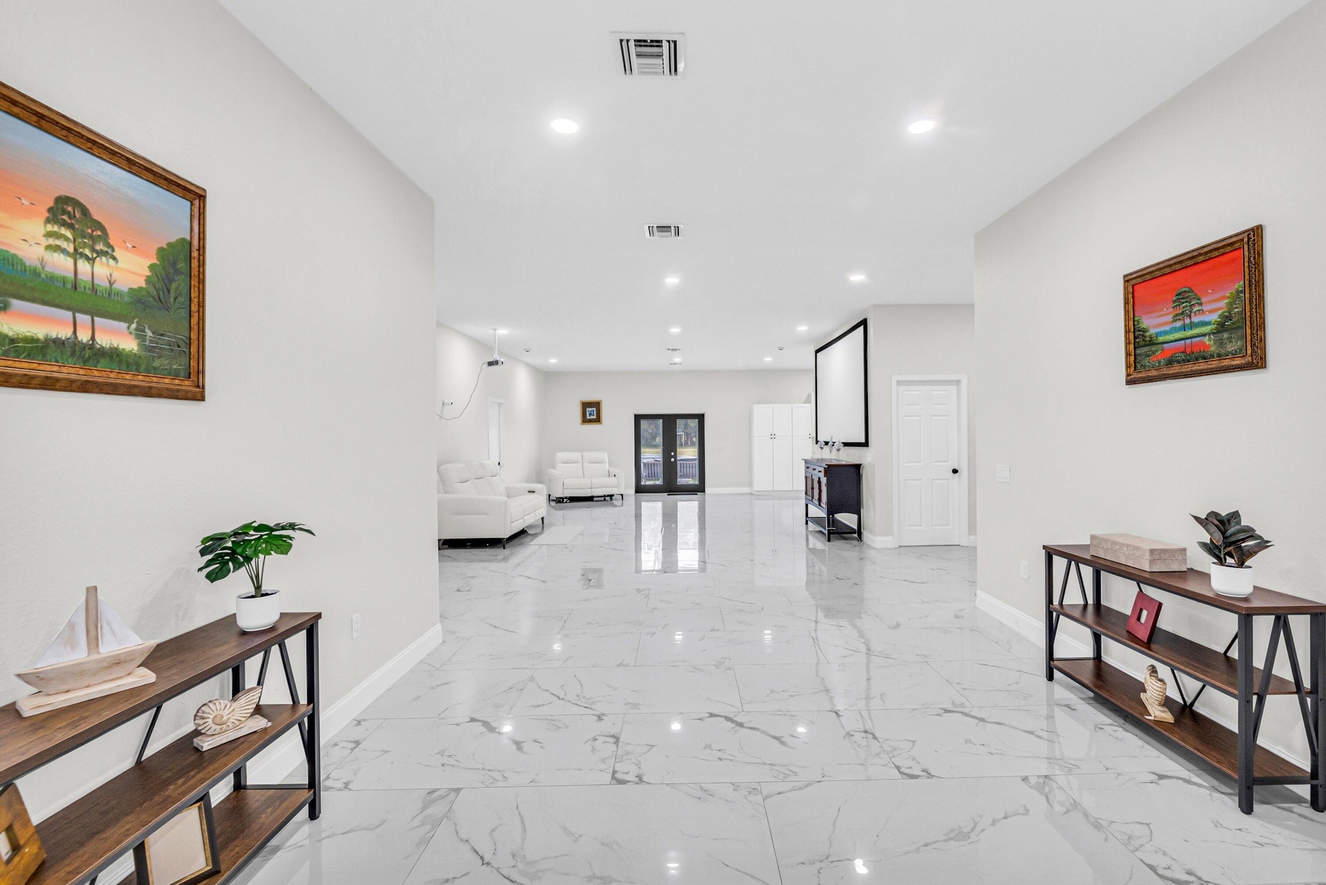 Open-concept living area with large-format tile and recessed lighting