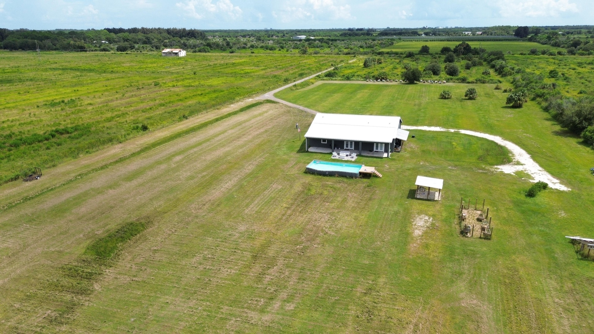 Aerial view of the home on nearly 10 acres with pool, guest unit and open land