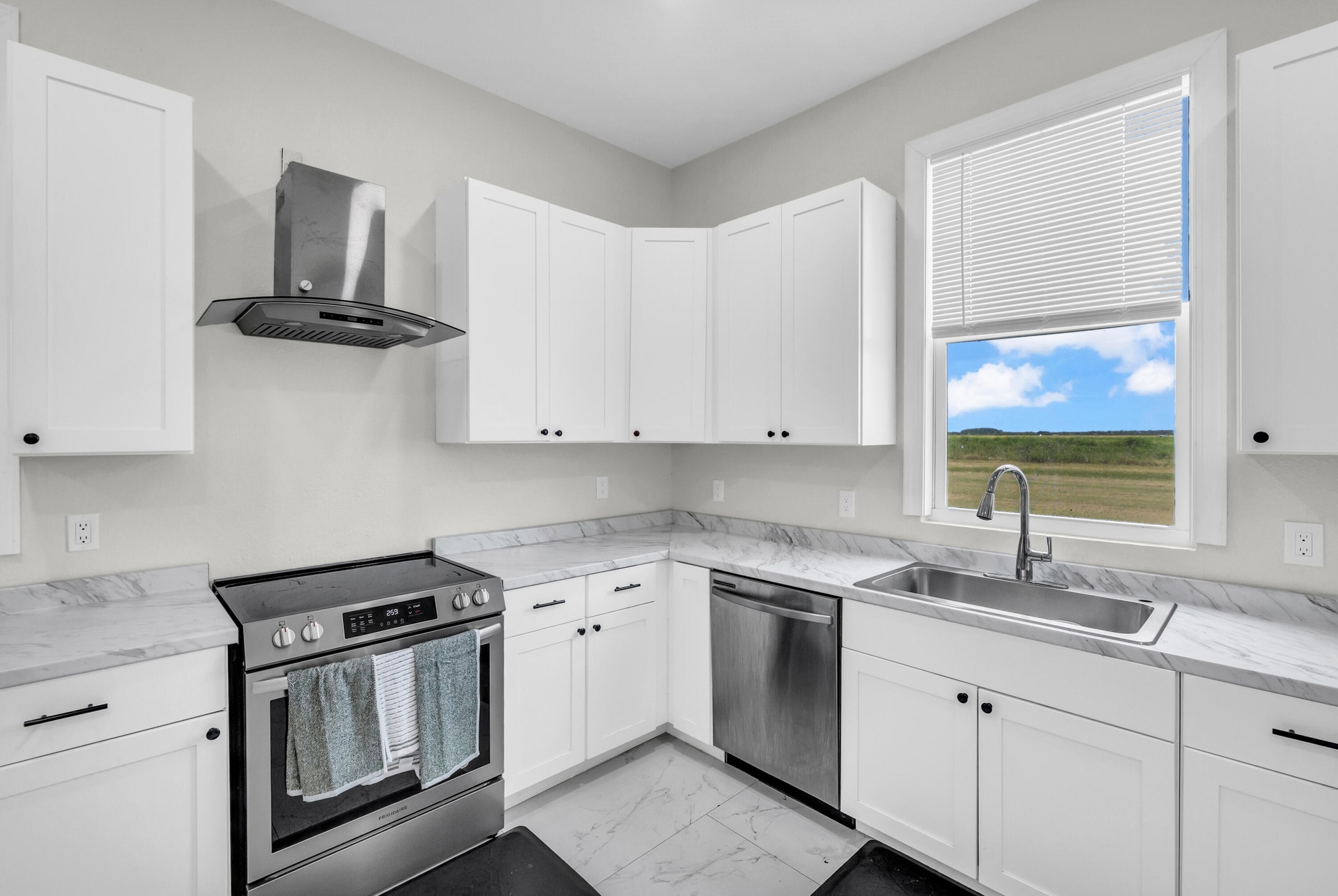 Kitchen with stainless range, dishwasher and window over the sink