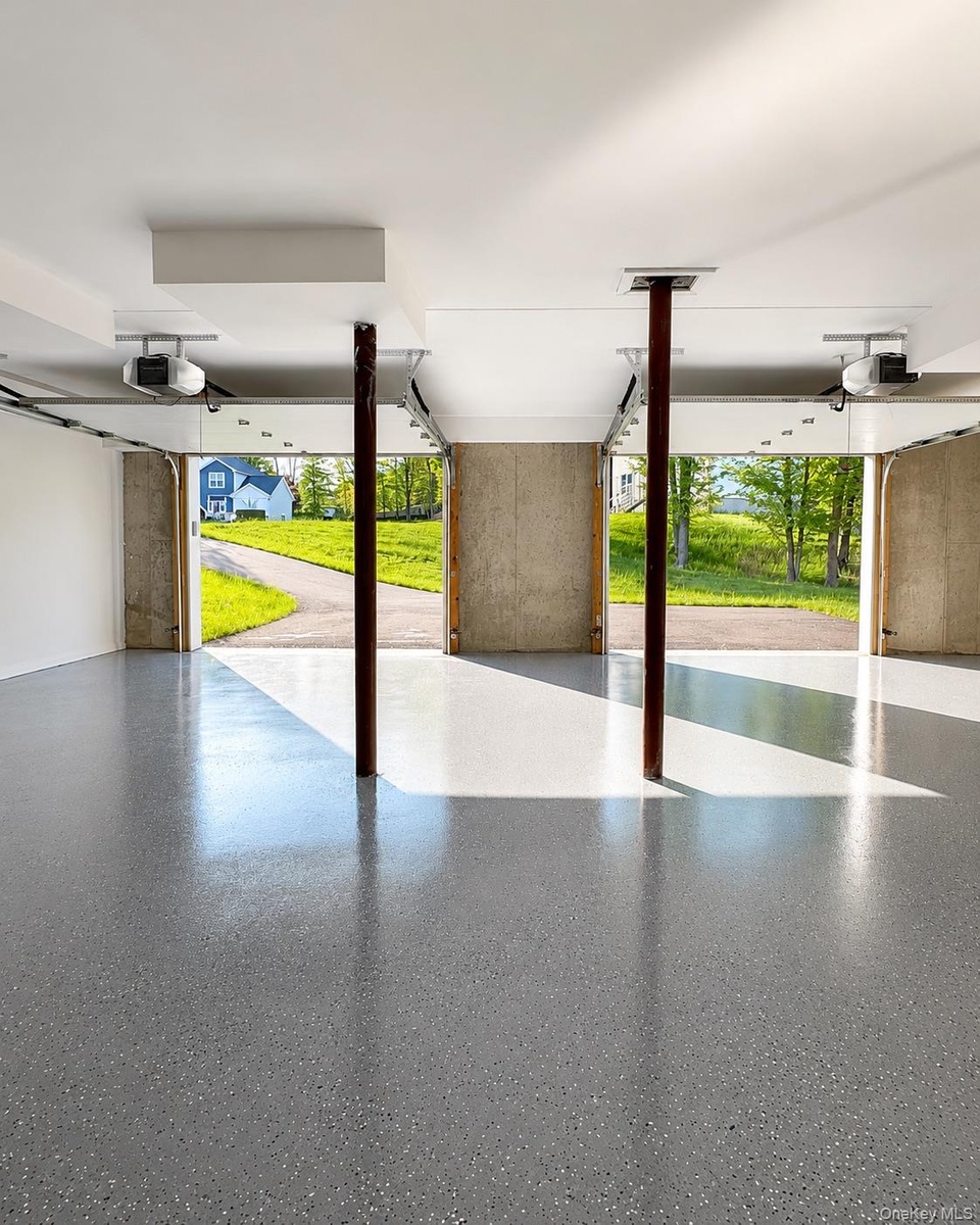 Expansive garage with a speckled epoxy floor finish and white painted walls
